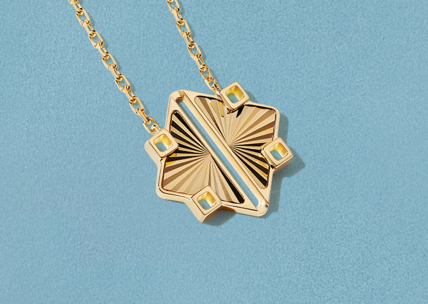  Birks Muse yellow gold necklace on a blue background.