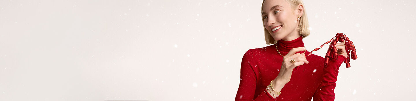 A person wearing a red sweater and Birks jewellery