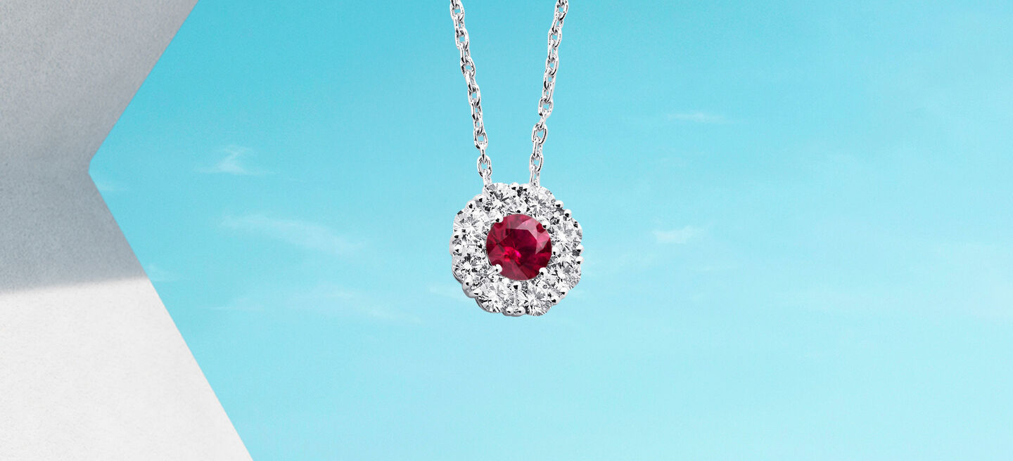 Birks Snowflake ruby and diamond necklace on a blue background.