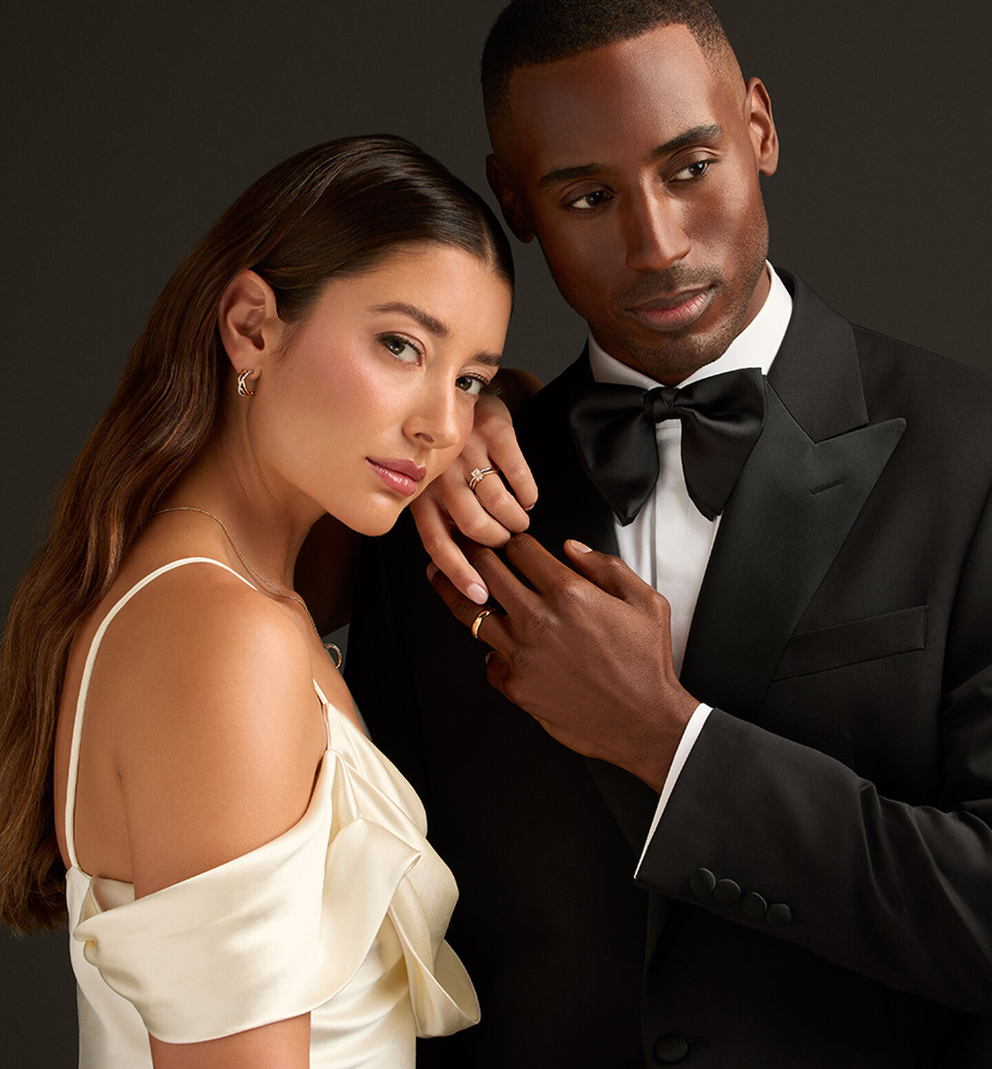 A couple wearing Birks Bridal jewellery, including an engagement ring and diamond jewellery.