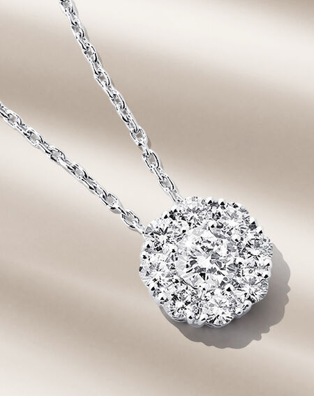 Collier Birks Snowflake avec diamants sur un fond beige.