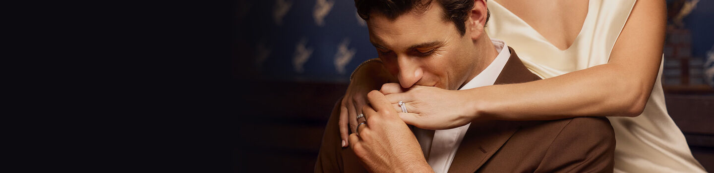 Birks wedding bands and diamond engagement ring on a couple&rsquo;s hands.
