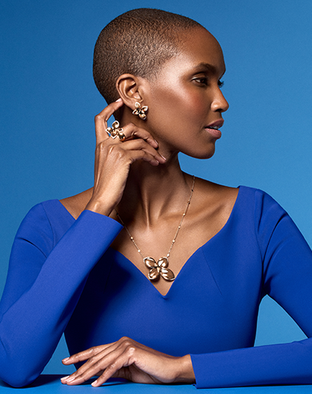 A woman wearing Pasquale Bruni jewellery on a blue background.