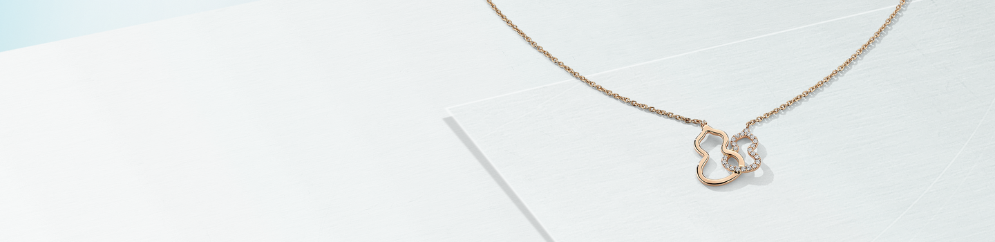 Qeelin wulu diamond necklace on a light blue background.