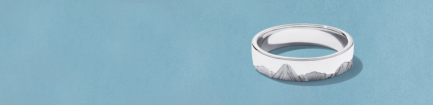 Birks men's silver irng on a blue background.