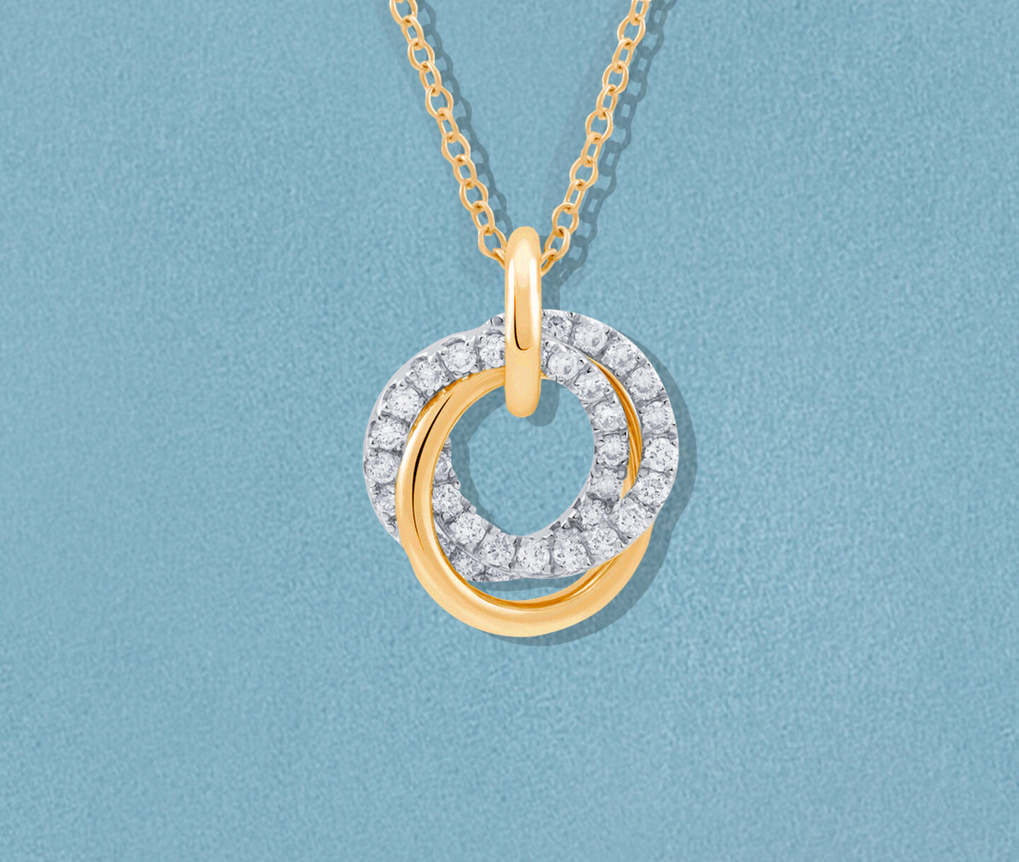 Birks Rosee du Matin diamond and yellow gold necklace on a blue background.