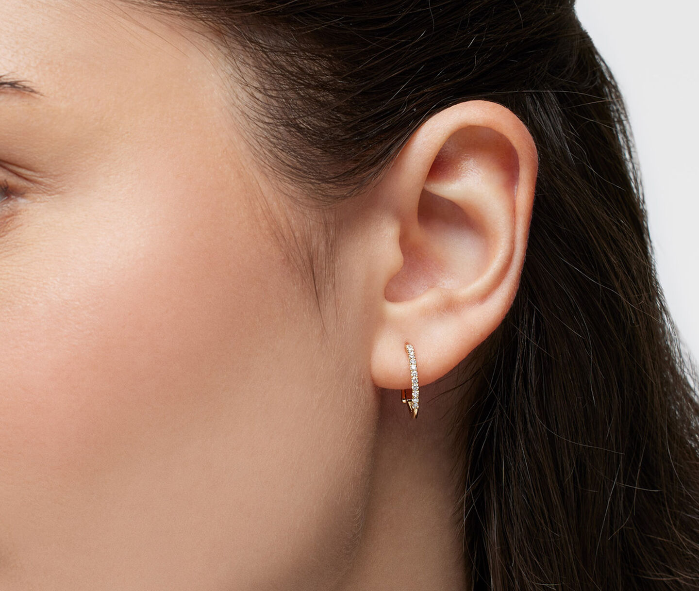 A woman wearing Birks Rosse du Matin diamond hoop earrings.