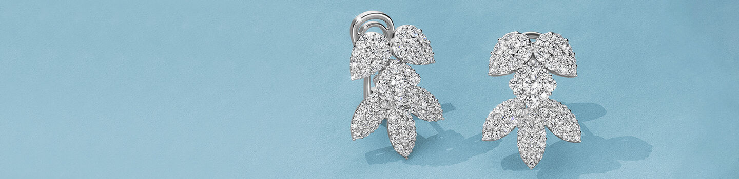 Birks Snowflake diamond earrings on a blue background