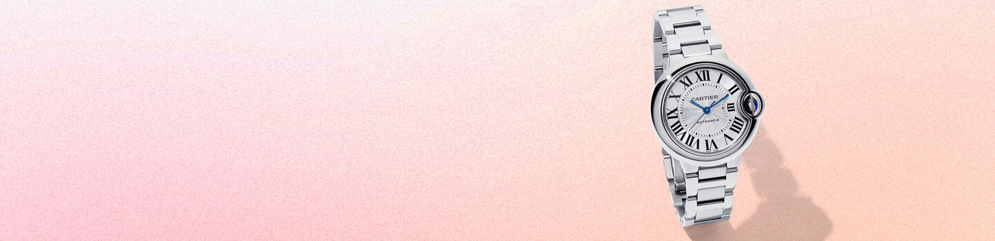 Montre Ballon Bleu de Cartier sur un fond rose et beige.