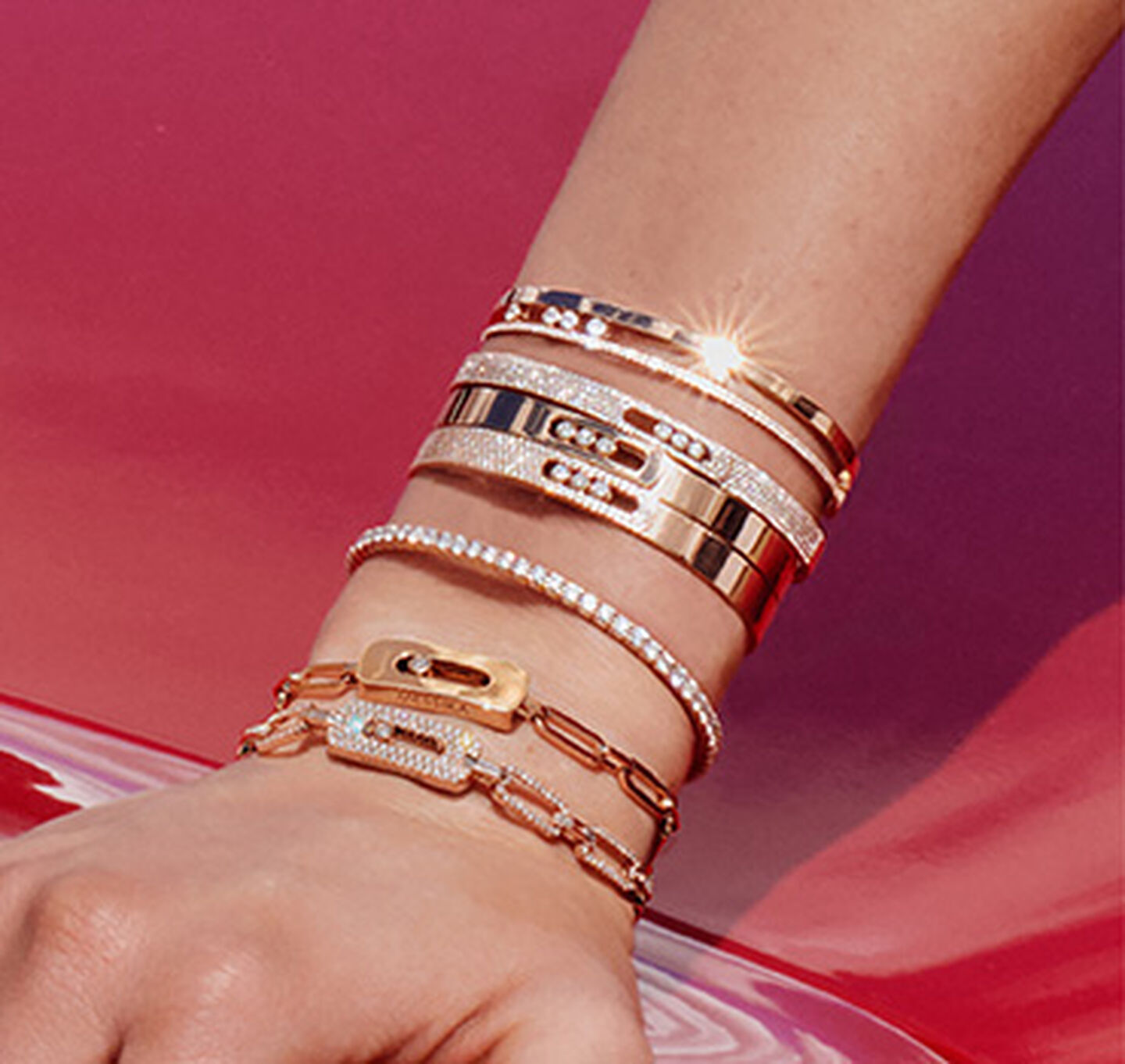 Stacked white, rose, and yellow gold Messika bracelets