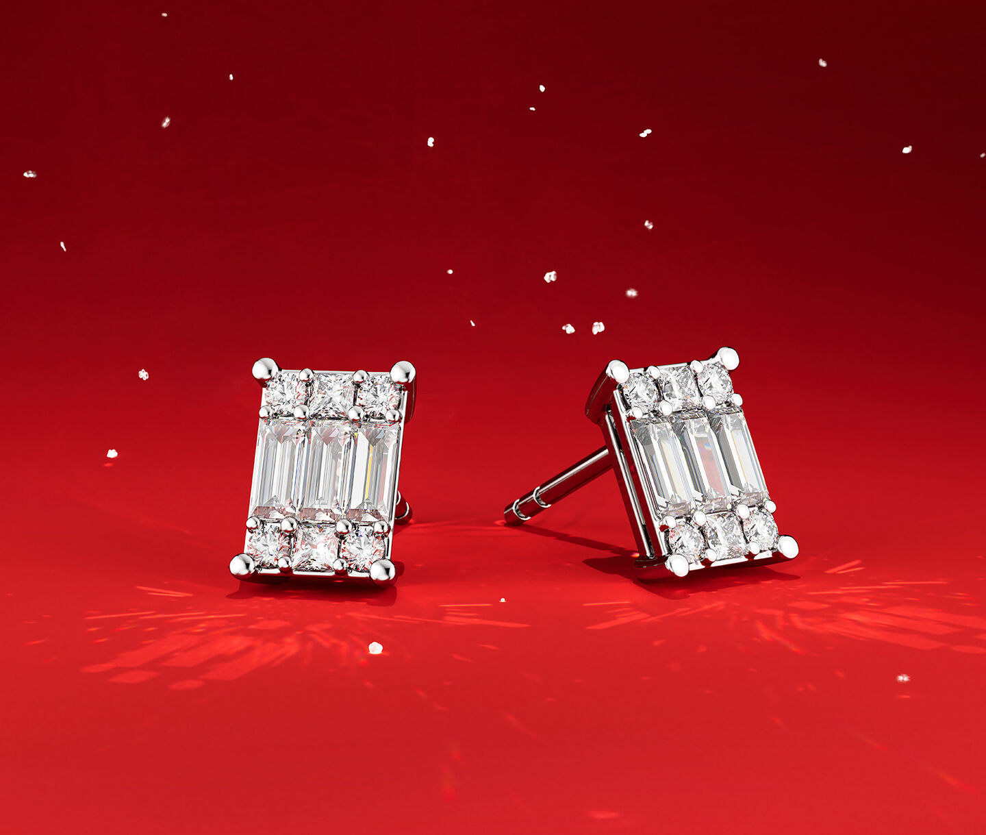 Birks essentials diamond stud earrings on a red holiday background.
