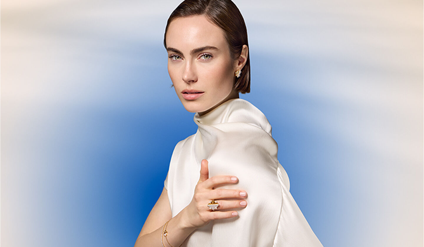 A woman wearing yellow gold jewellery from Birks Muse.