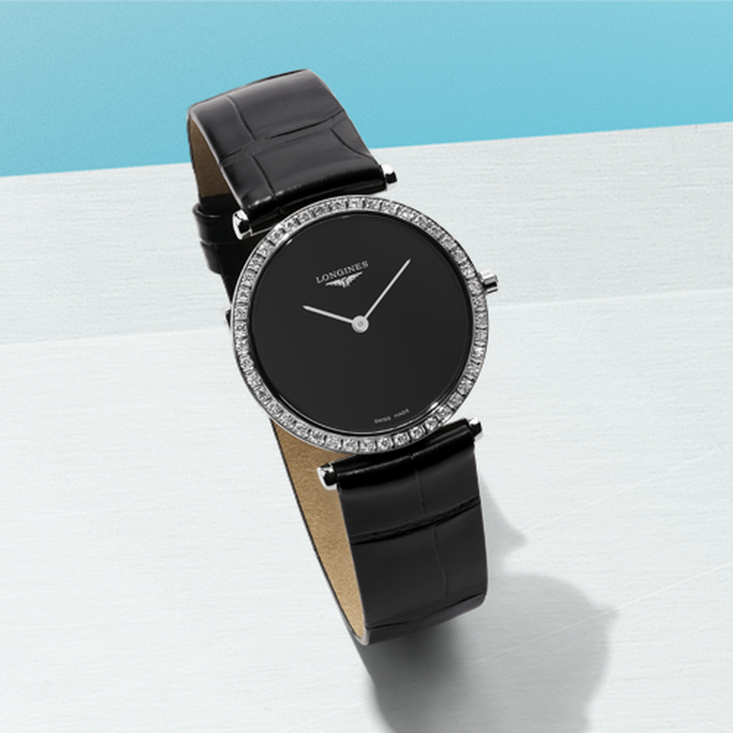 Montre La Grande Classique de Longines sur un fond bleu.