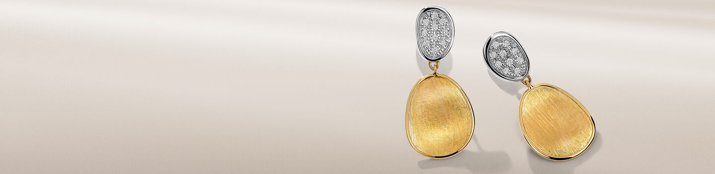 Marco Bicego Lunaria diamond earrings on a beige background.