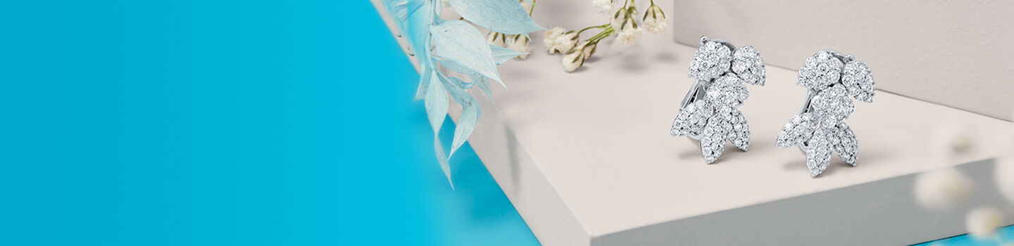 Boucles d'oreilles en diamant Birks Snowflake Snowstorm posées sur une table