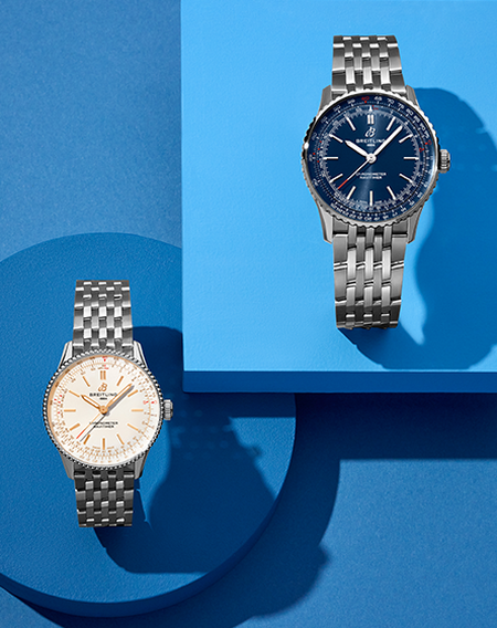 Breitling Navtimer watches on a blue geometric background.