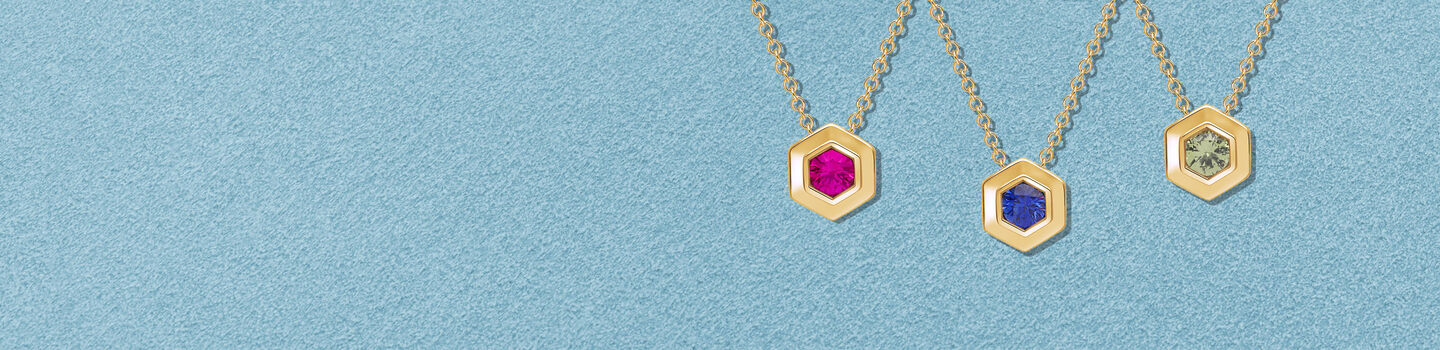 Collier en argent Birks Bee Chic ao&ucirc;t, septembre, et octobre en or jaune sur un fond bleu.