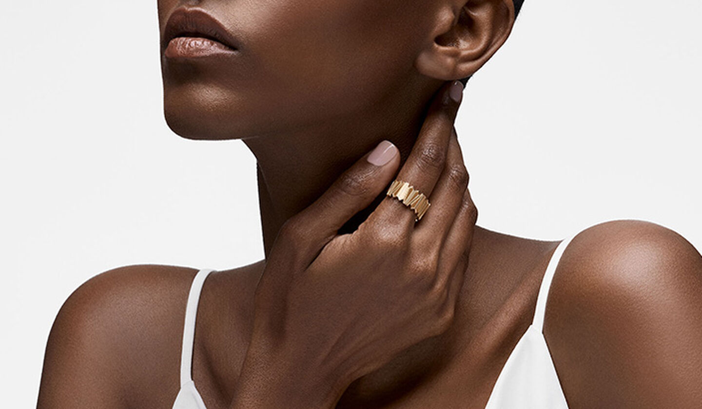 Une femme porte la bague Birks Beekeeper en or jaune.