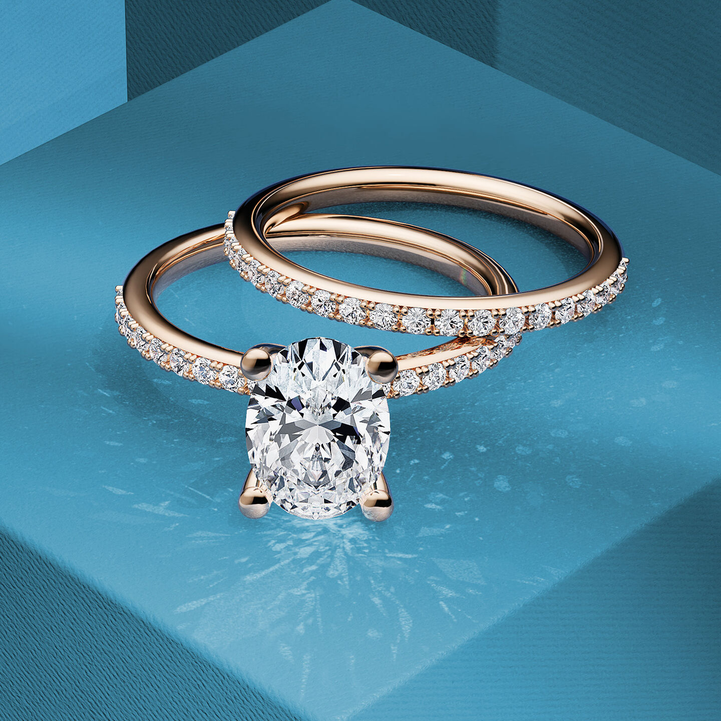 A rose gold Birks diamond engagement ring and wedding band resting on a blue box.