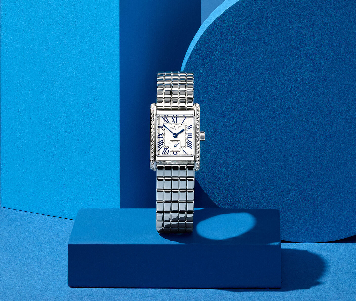 Longines DolceVita women's watch on a blue background.