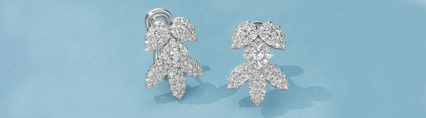 Boucles d'oreilles Birks Snowflake sur un fond bleu.