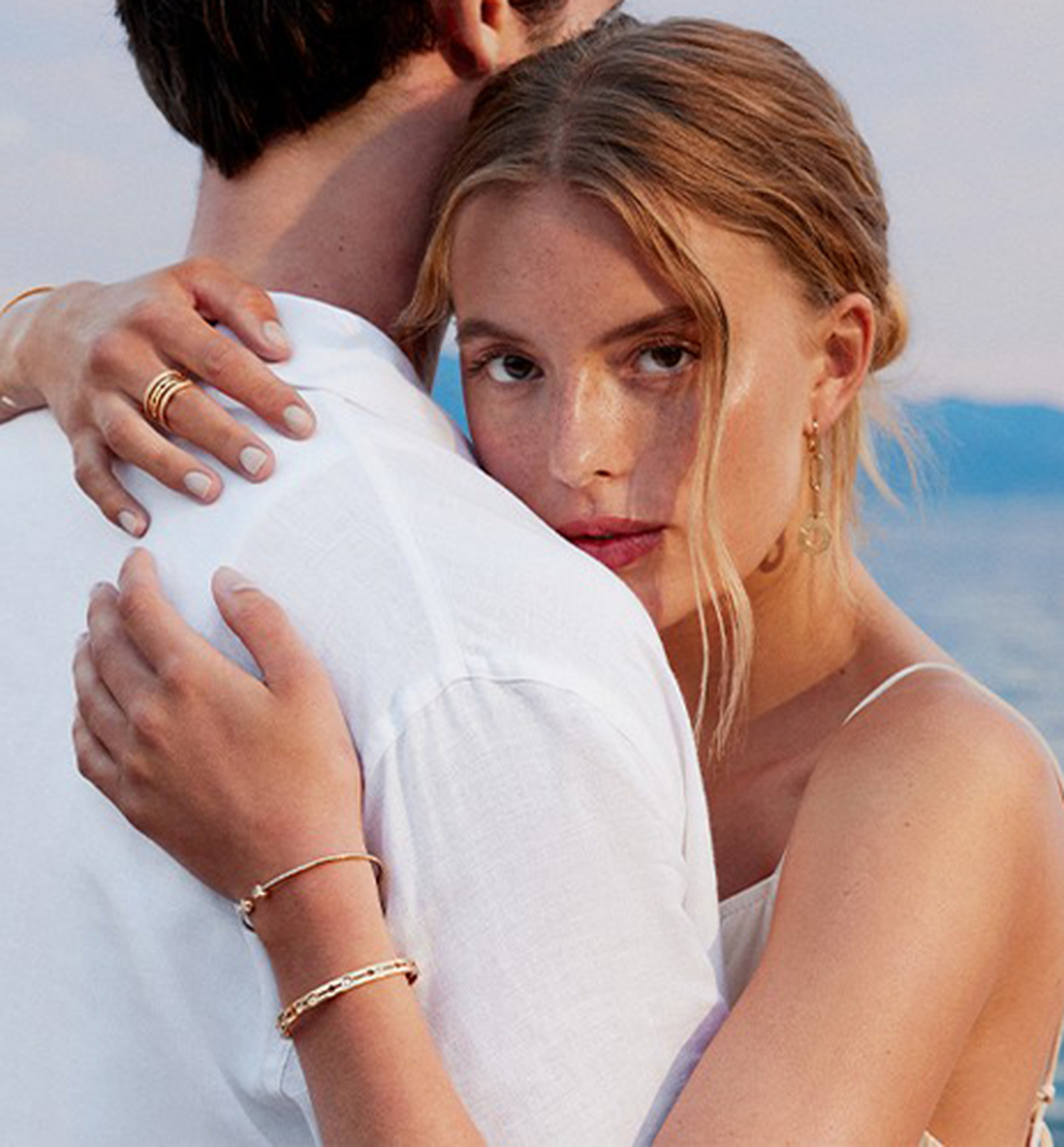 A woman embracing a man wearing dinh van jewellery.