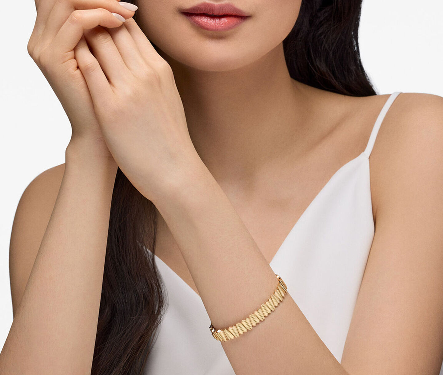 A woman wearing the Birks Beekeeper yellow gold bangle bracelet.