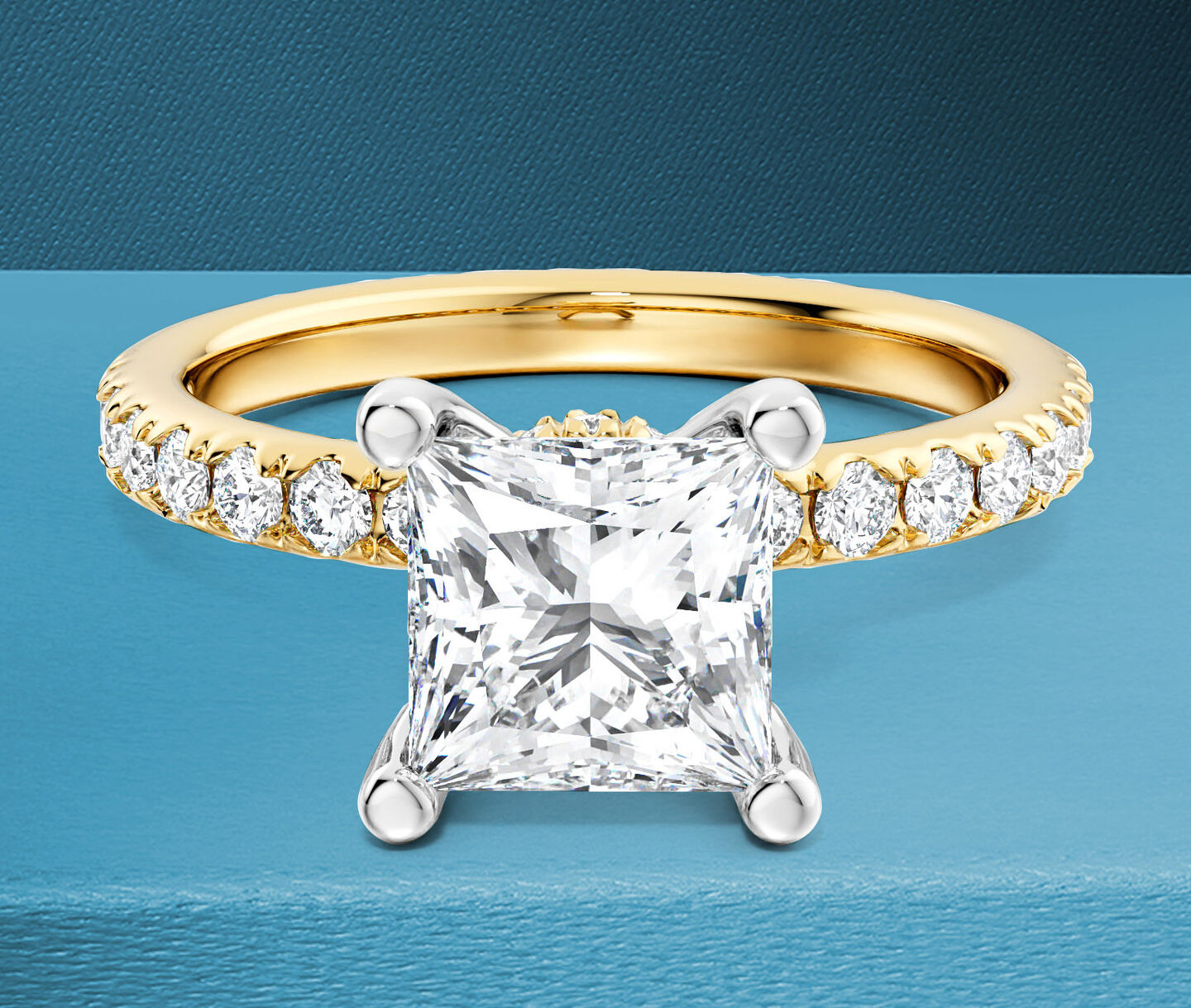 Birks Deco princess-cut diamond engagement ring on a blue background.