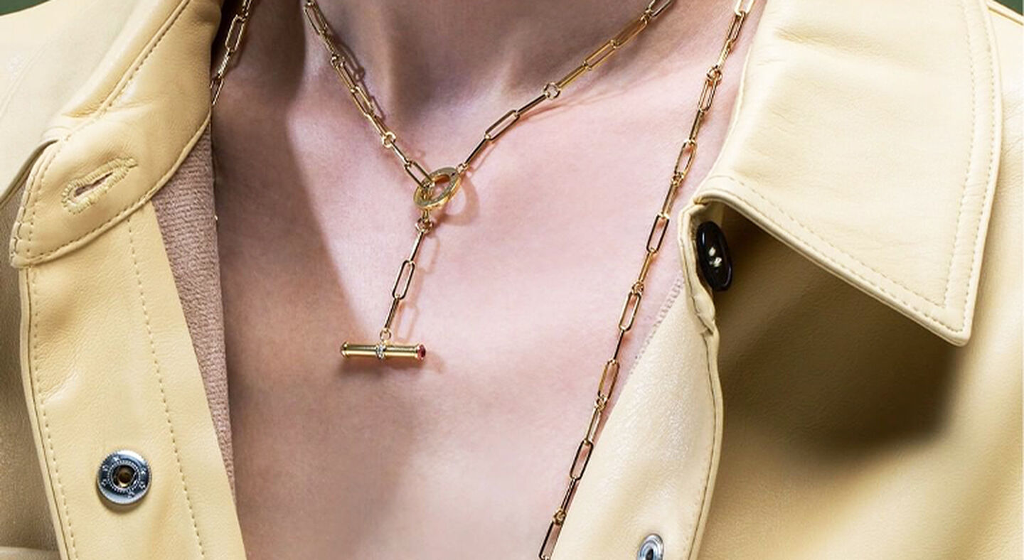 Model wearing a yellow leather jacket and Designer Gold necklace.