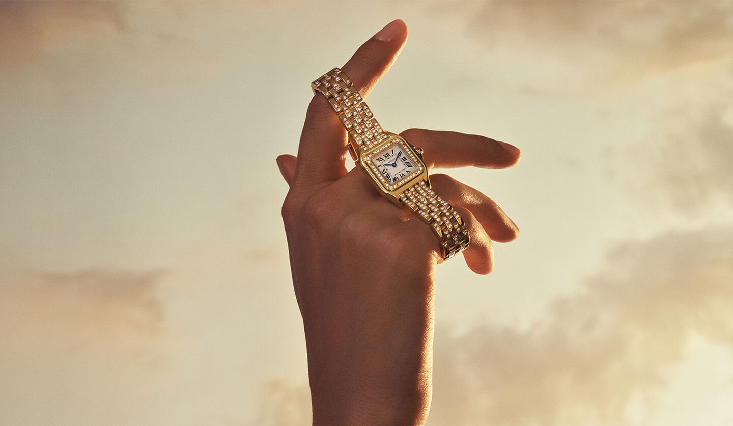 A woman holding a Panth&egrave;re de Cartier watch.