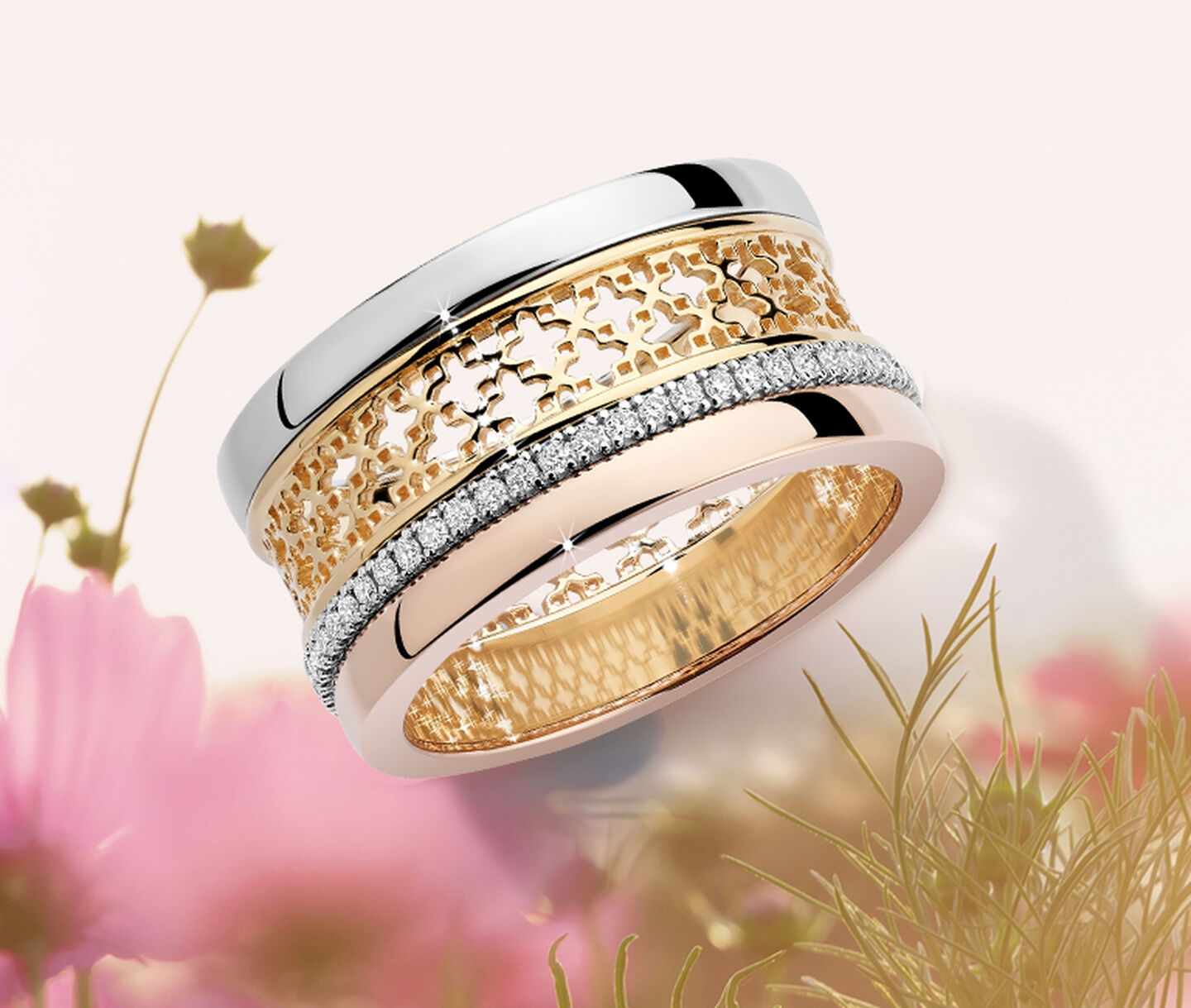A Birks Dare to Dream tri-gold ring on a floral background.