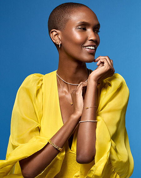 A woman wearing Pasquale Bruni jewellery on a blue background.