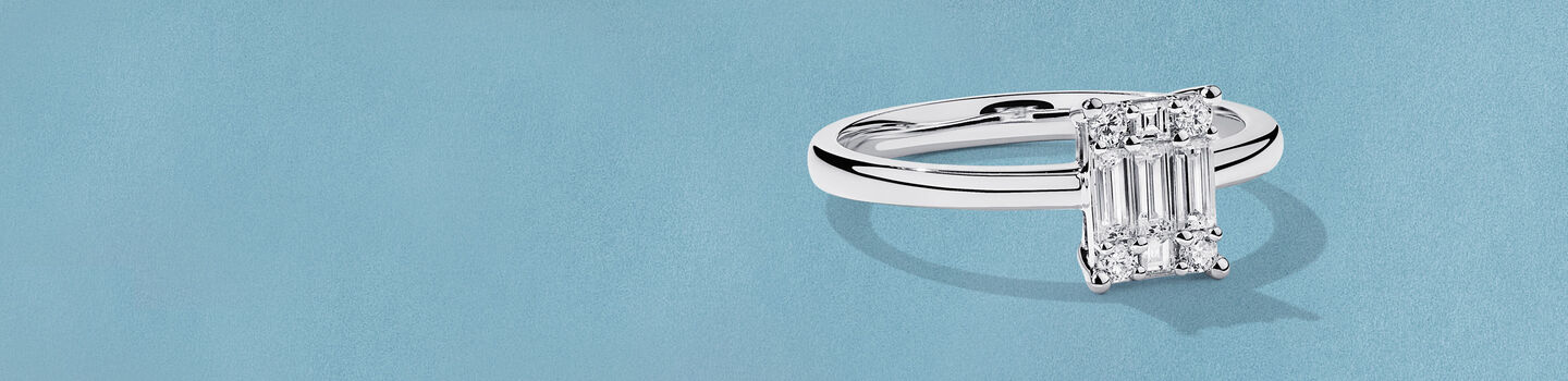 Bague avec diamants Birks Essentiels sur un fond bleu.