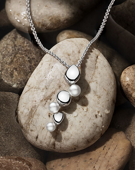 Birks Pebble necklace on a flat grey pebble background