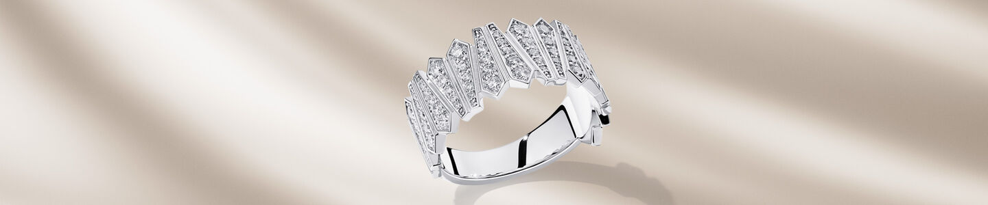 Birks Beekeeper white gold and diamond ring on a beige background.