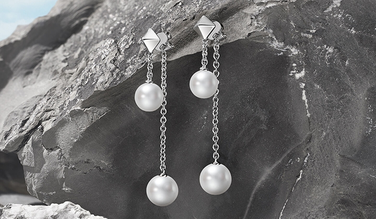 Birks Rock and Pearl Drop earrings on a grey-charcoal background.