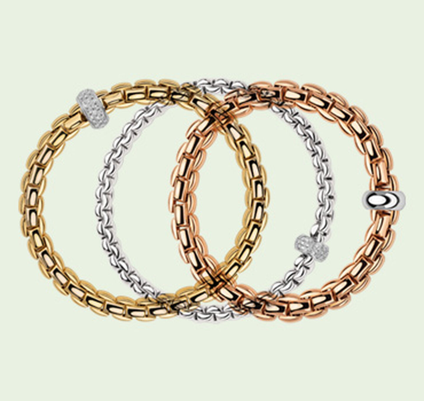 Trois bracelets Eka de FOPE sur un fond vert.