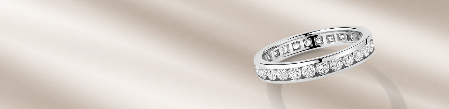 Birks diamond eternity ring on a beige background.