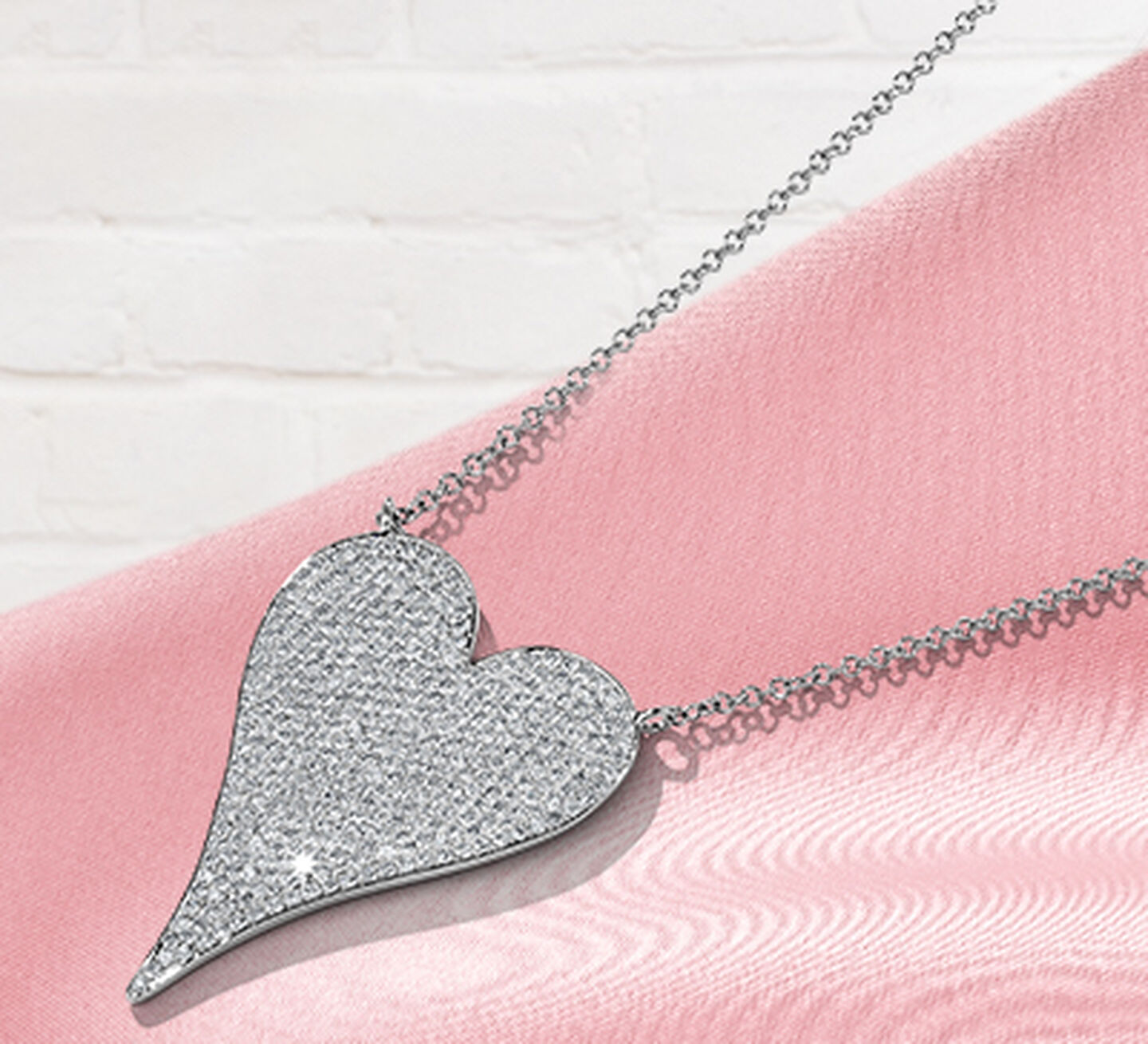 Shy Heart Necklace with pave diamonds in pink satin background