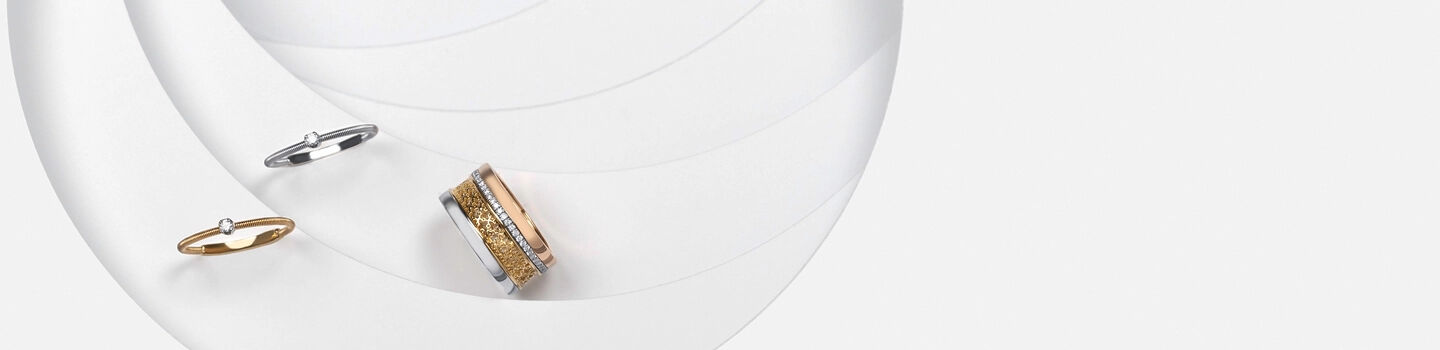 Tri-gold ring beside a yellow and white gold diamond ring
