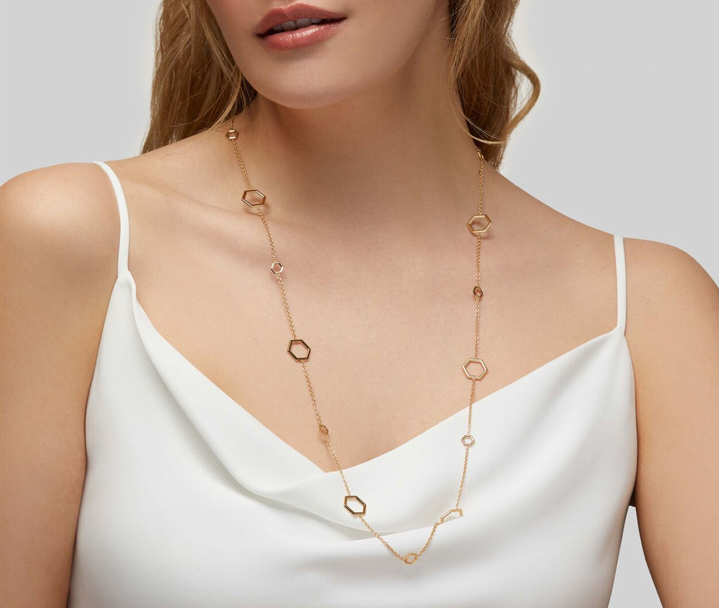 Une femme porte un collier Birks Bee Chic en or jaune.