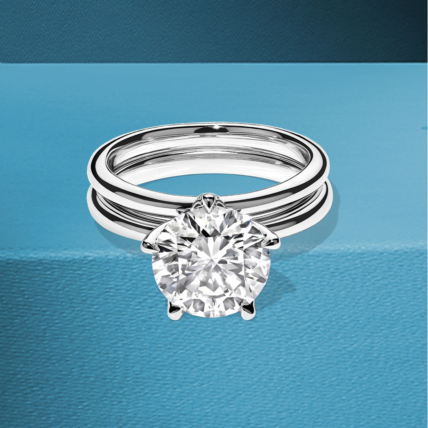 Birks North Star diamond engagement ring and wedding band on a blue background.