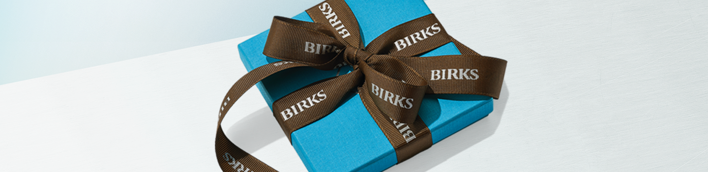 Boîte bleue de Maison Birks sur un fond bleu clair. 