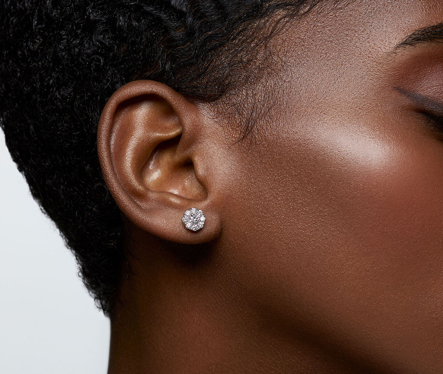 A woman wearing Birks Snowflake diamond cluster earrings.