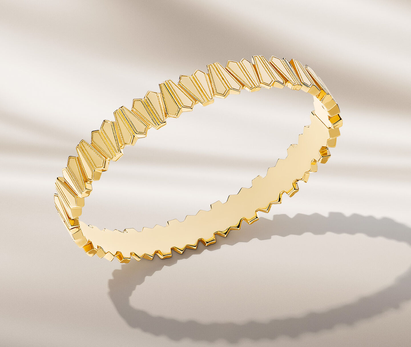 Bracelet Beekeeper en or jaune sur un fond beige.