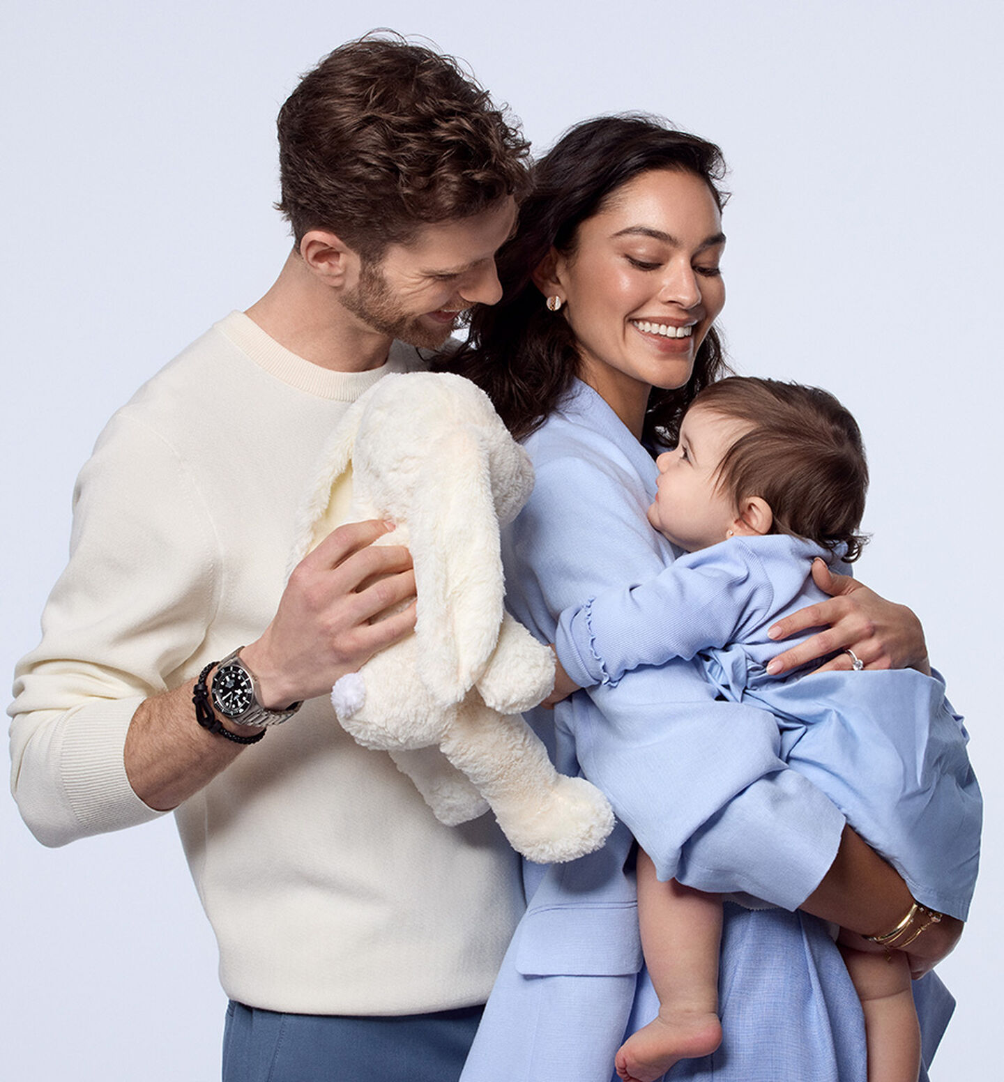 A couple wearing jewellery and watches from Maison Birks holding a child.