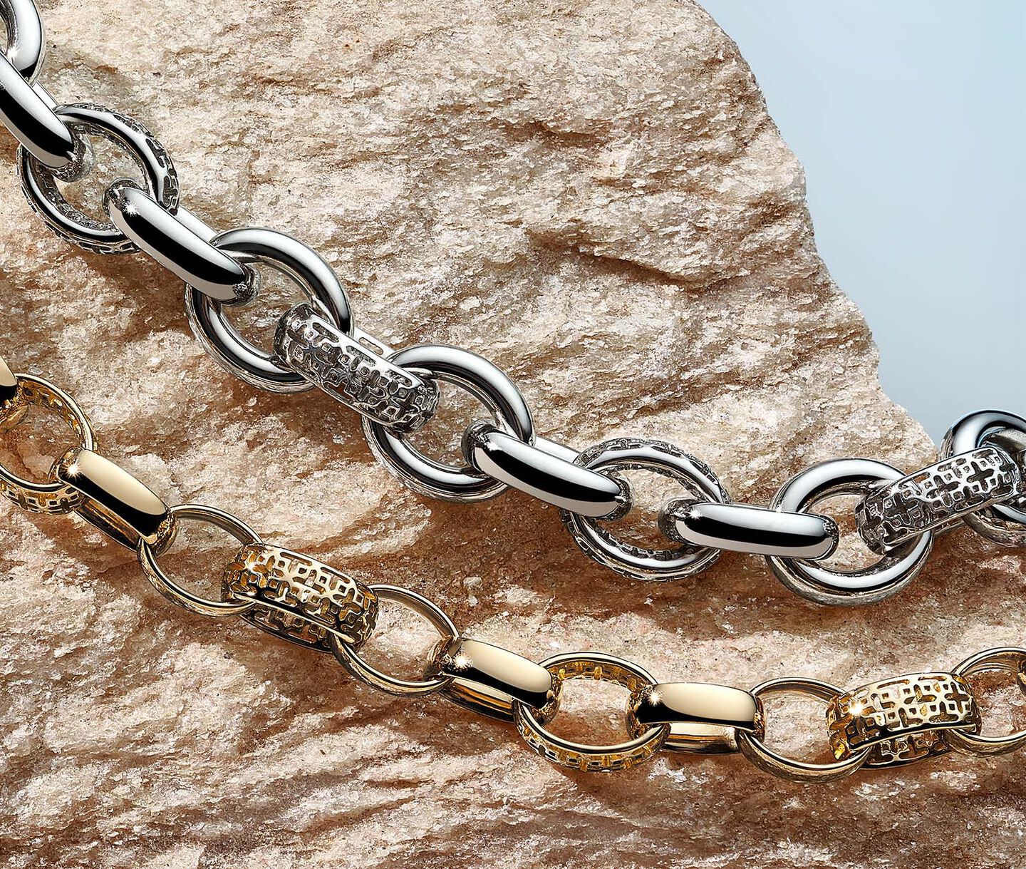 Silver and gold Birks Muse bracelets on a rock.