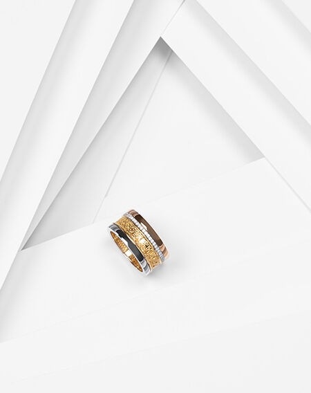 Birks Dare to Dream tri-gold diamond ring on a white layered background.