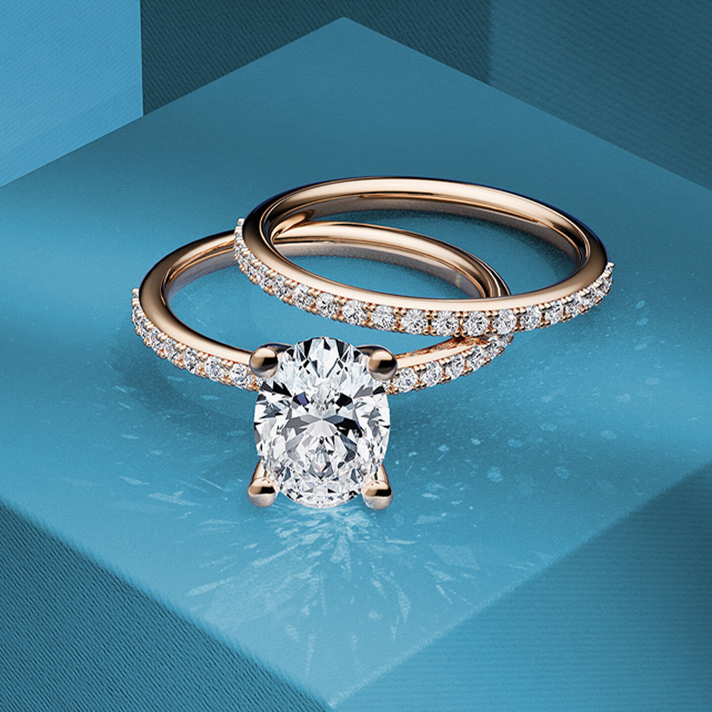 Birks Rosée du Matin rose gold and oval-cut engagement ring and diamond wedding band on a blue background.