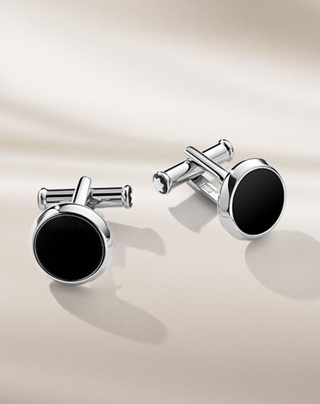 Montblanc cufflinks on a beige background.